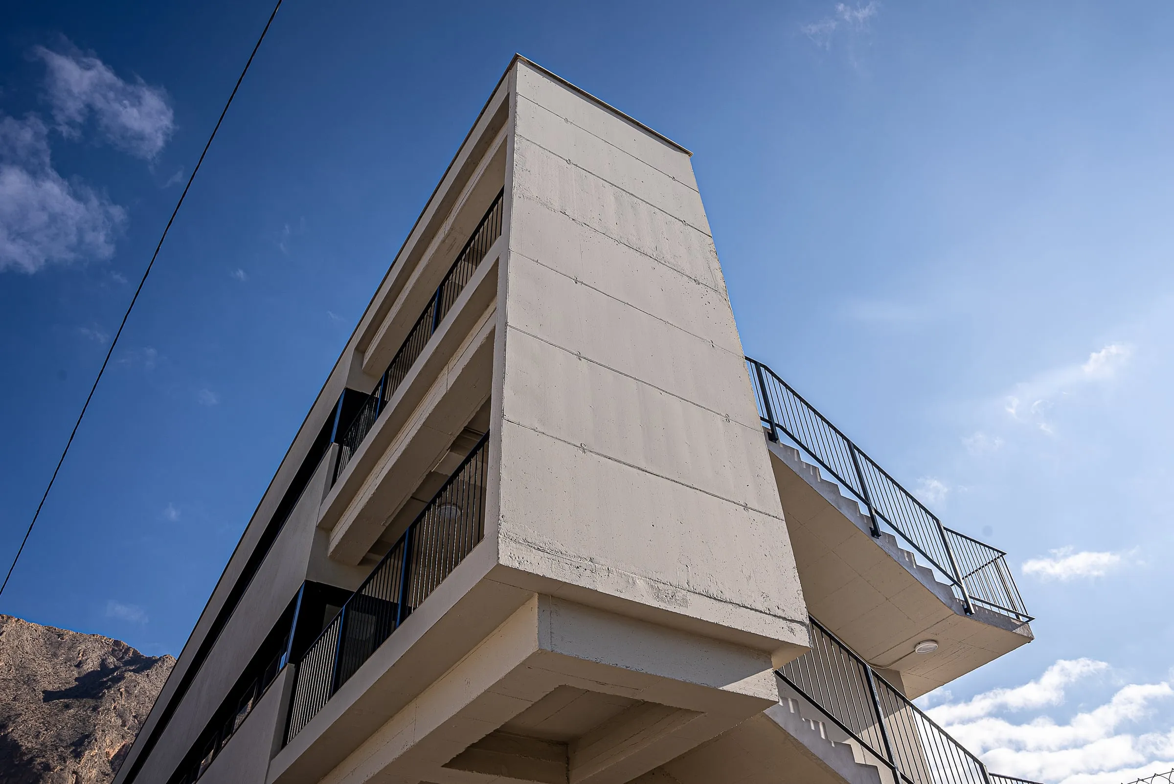 Voladizo de la escalera exterior del nuevo edificio recortado contra el cielo